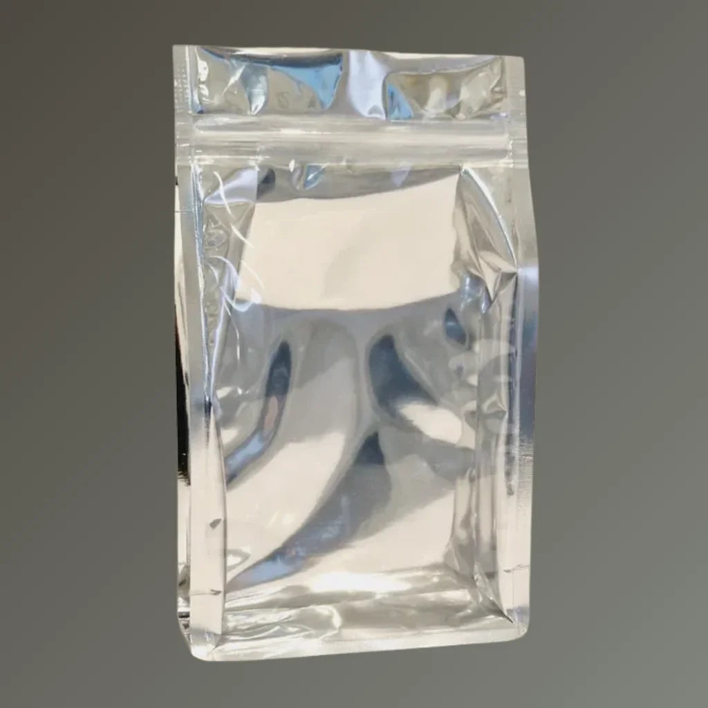 Chrome back clear front resealable flat bottom pouch, shown upright against a grey background.