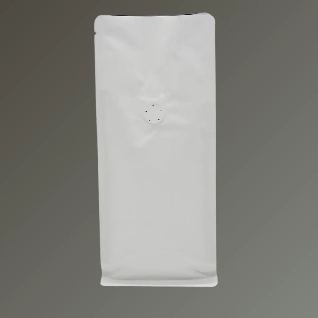 White flat bottom coffee pouch with open top and one-way degassing valve, displayed against a grey background.