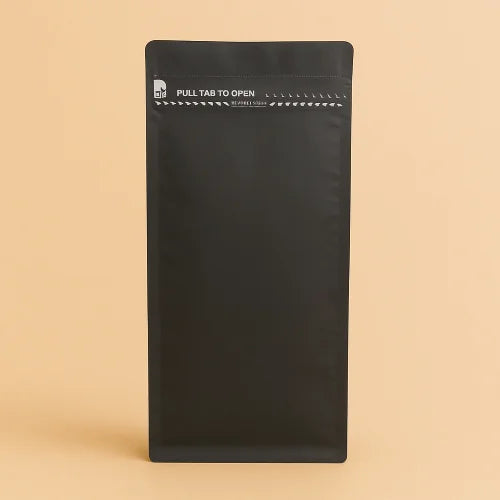 Black I'm Green flat bottom bag with a pull tab to open, displayed upright against a beige background, featuring a resealable top.