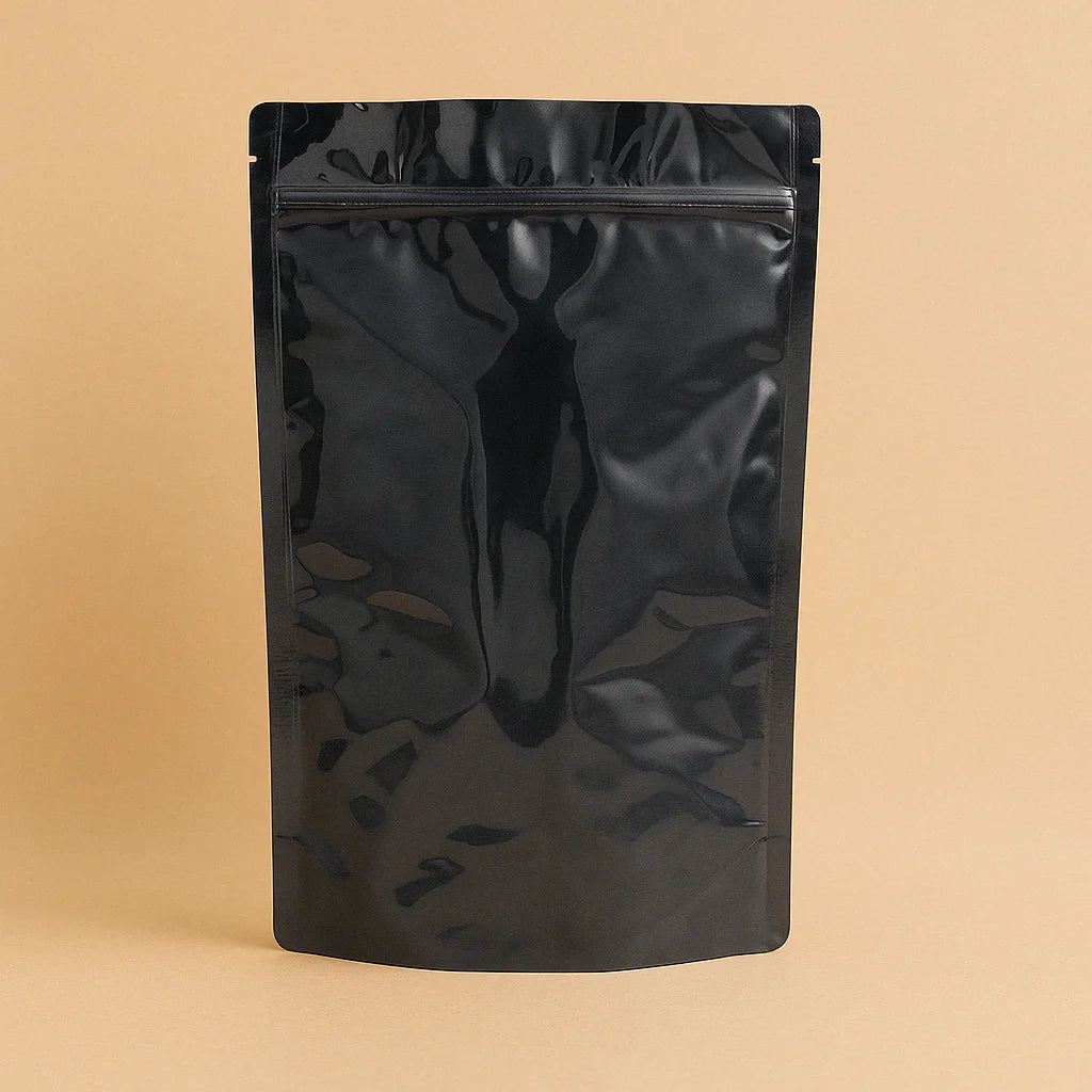 Black resealable stand up pouch with heat-sealable top and press-to-close strip, displayed upright against a light brown background.