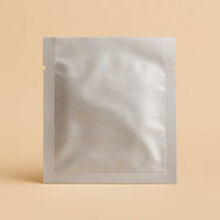 Silver three side seal open top sachet with tear notches, displayed upright against a beige background.