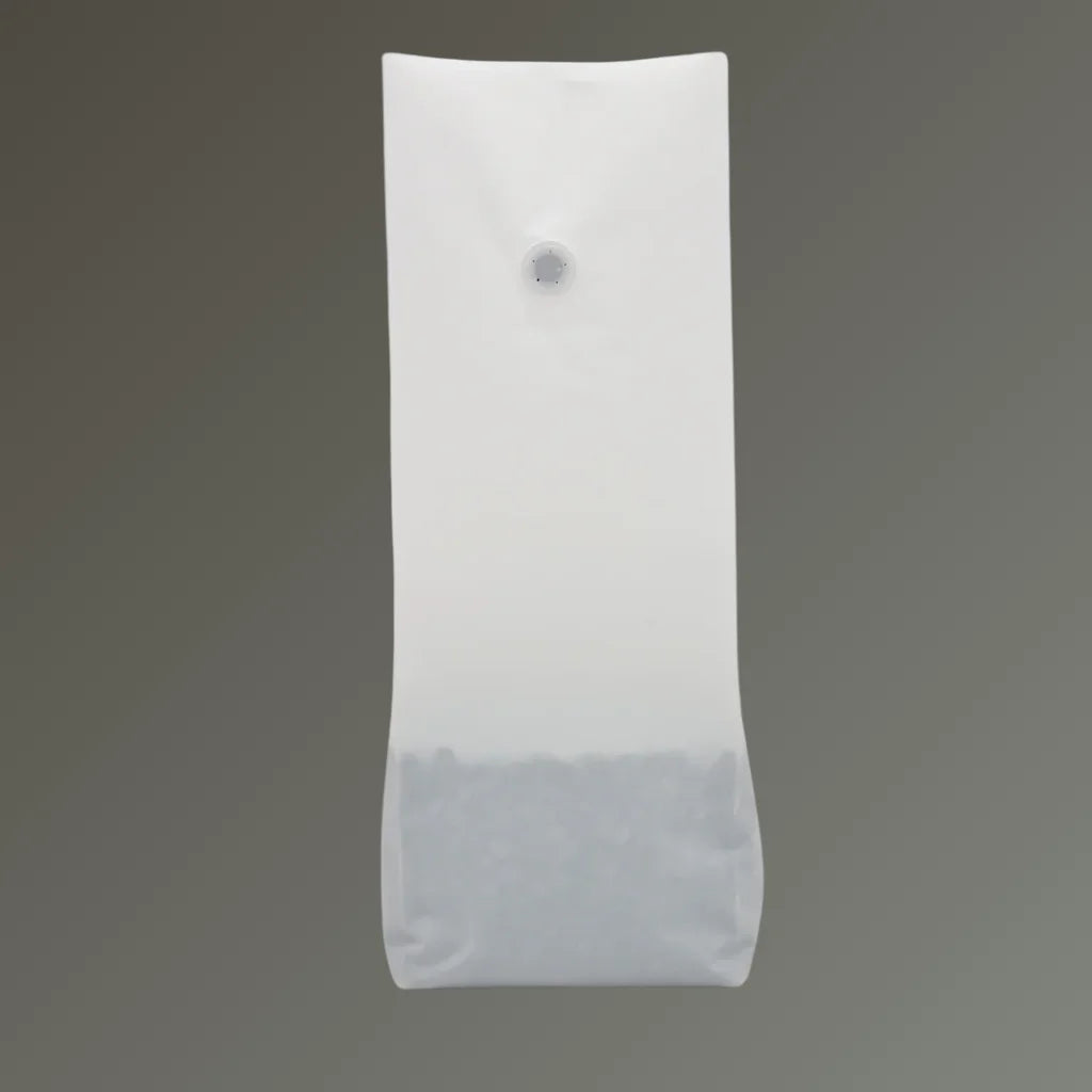 Matt white recyclable coffee pouch with open top and one-way valve, displayed upright against a grey background.