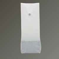 Matt white recyclable coffee pouch with open top and one-way valve, displayed upright against a grey background.