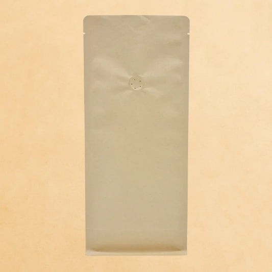 Brown kraft flat bottom coffee bag with one-way valve and open top, displayed upright against a beige background.