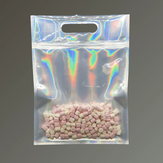 Iridescent holographic pouch with handle and resealable closure, filled with pink and white pellets, displayed upright against a grey background.
