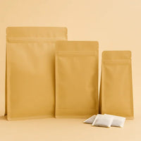 Brown kraft resealable flat bottom pouches in three sizes, displayed upright with sample sachets on a beige background.