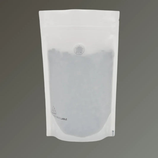 Recyclable matt white stand up coffee pouch with open top and one-way valve, displayed upright against a grey background.