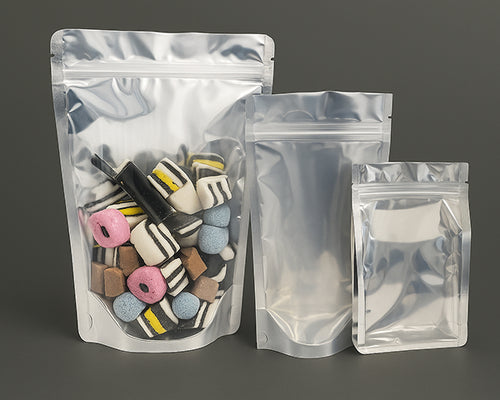 Set of three metallic stand-up pouches with different contents on a gray background