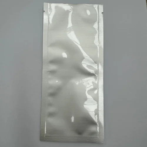Aluminium sachet pouch with three side seals, shown flat against a grey background.