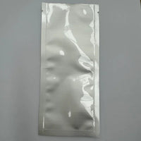Aluminium sachet pouch with three side seals, shown flat against a grey background.