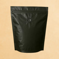 Back view of a lack stad up resealable coffee pouch with a degassing valve.