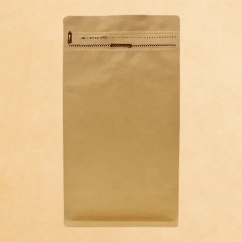 Kraft flat bottom coffee pouch with Rip n Zip opening and one-way valve, displayed upright against a beige background.