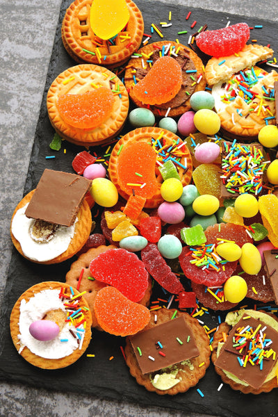 Assorted small pastries and candies on a dark surface