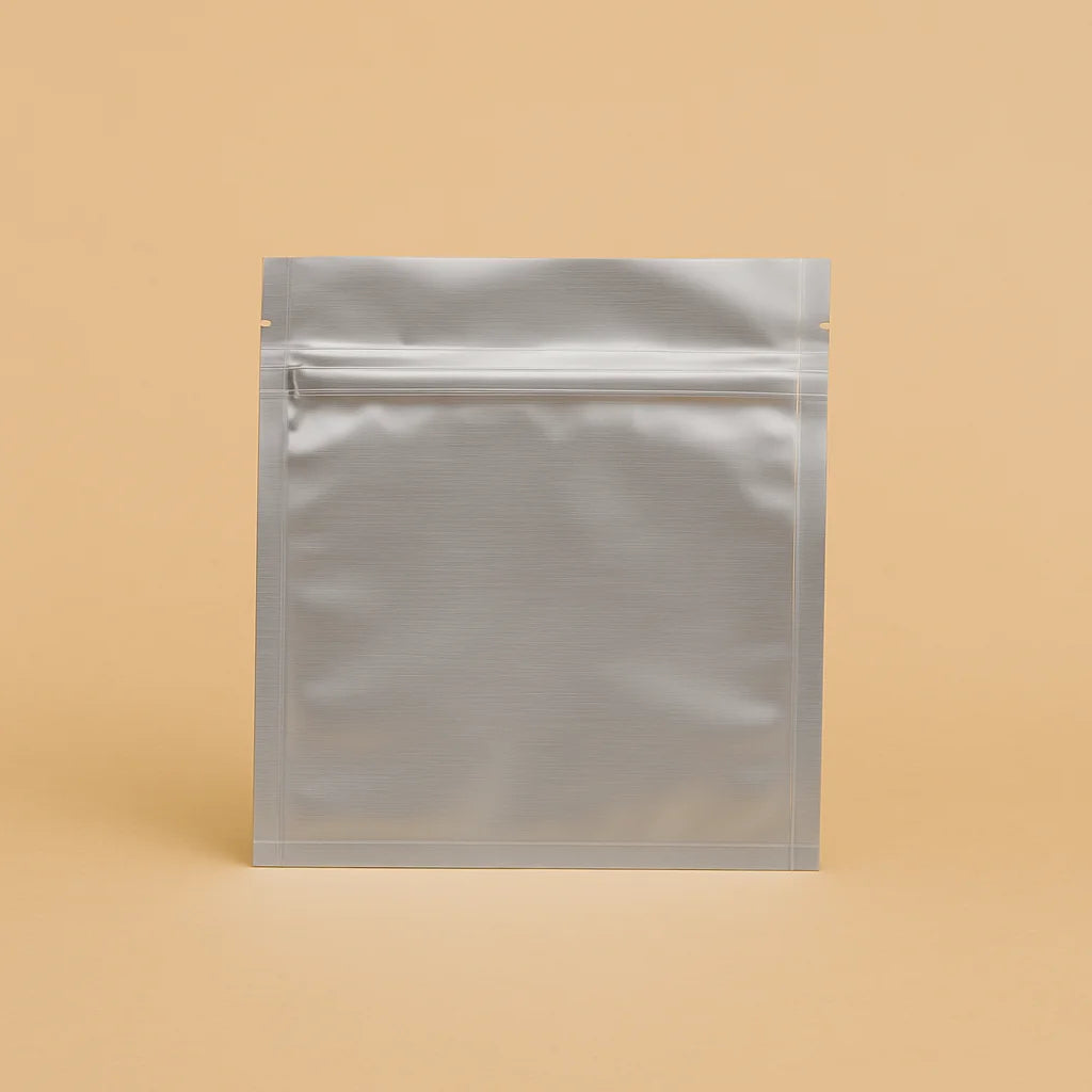 Silver flat pouch with resealable zipper, displayed upright against a beige background, ideal for food or supplement storage.