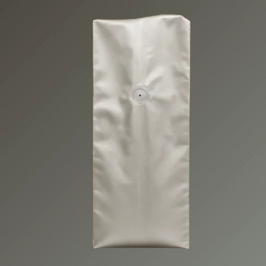 Silver foil side gusset coffee bag with one-way valve and open top, displayed upright against a grey background.