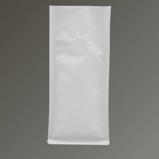 White open top coffee pouch with one-way degassing valve, standing upright on a grey background.